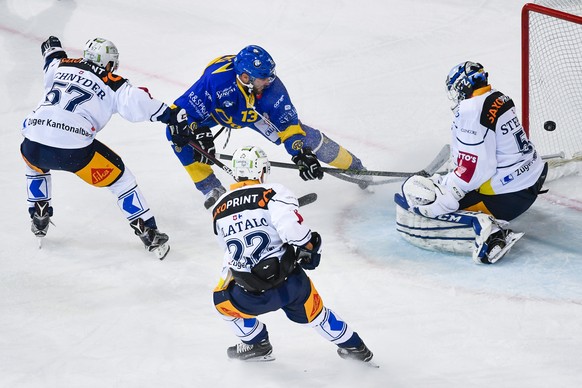 Robert Kousal von Davos, Mitte, trifft zum 1-0 gegen Fabian Schnyder, Santeri Alatalo und Torhueter Tobias Stephan von Zug, von links, beim Eishockey-Qualifikationsspiel der National League A zwischen ...