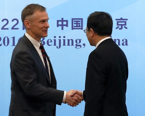 FILE - In this Nov. 21, 2016, file photo, Deputy Chief of Mission of U.S. Embassy Beijing David Rank, left, shakes hands with Director-General of the Department of Treaty and Law of the Foreign Minist ...