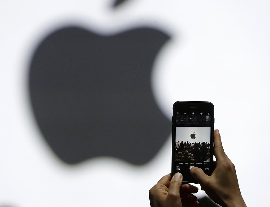 FILE - In this Monday, June 5, 2017, file photo, a person takes a photo of an Apple logo before an announcement of new products at the Apple Worldwide Developers Conference in San Jose, Calif. Apple i ...