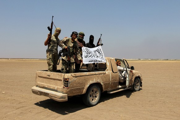 Fighters of the Syrian Islamist rebel group Jabhat Fateh al-Sham cheer on a pickup truck after a Russian helicopter was shot down in the north of Syria&#039;s rebel-held Idlib province, Syria, August  ...