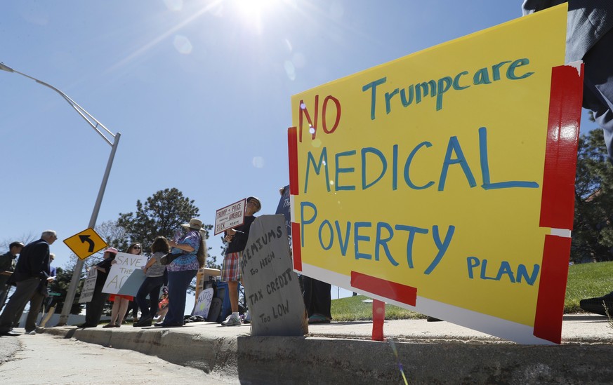 People wave placards during a protest outside the office of U.S. Rep. Mike Coffman, R-Colo., over the health care overhaul bill up for a vote in the U.S. House Thursday, May 4, 2017, in Aurora, Colo.  ...