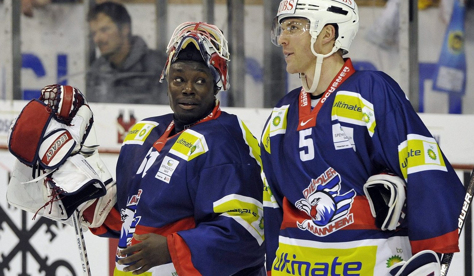 Mannheim&#039;s goalkeeper Fred Brathwaite, left, talks with his teammate Andy Hedlund during the game between Germany team Adler Mannheim and team Canada at the 83rd Spengler Cup ice hockey tournamen ...