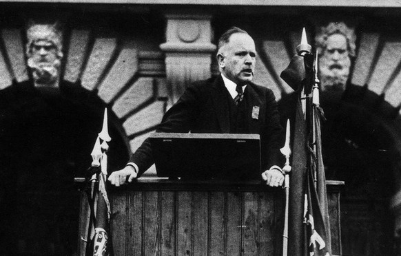 Robert Grimm holds a speech in front of the Federal Palace (seat of government and parliament) in Berne, Switzerland, ca. 1920. The SP parliamentarian was a very influential person in leftist politica ...
