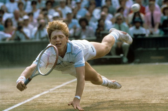Der deutsche Tennisspieler Boris Becker hechtet während des Turniers in Wimbledon im Juli 1985 hinter einem Ball her. Als jüngster Spieler und erster Deutscher überhaupt gewann der ungesetzte Boris Be ...