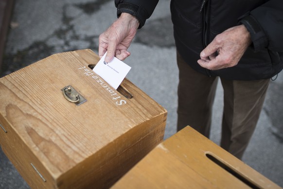 Ein Dorfbewohner stimmt an der Urne ab, am Sonntag, 18. Oktober 2015, in Obersaxen Meierhof. Heute finden die eidgenoessischen Wahlen 2015 in der Schweiz statt. Dabei werden die 200 Mandate des Nation ...