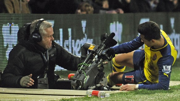 epa04648028 Arsenal&#039;s Alexis Sanchez falls into the TV pit during the English Premier League match Queens Park Rangers vs Arsenal FC at Loftus Road, London, Britain, 04 March 2015. EPA/GERRY PENN ...