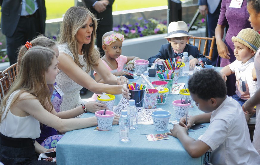 First lady Melania Trump sits with a group of children to color and draw following a ribbon cutting ceremony and grand opening of the Bunny Mellon Healing garden at Children&#039;s National Hospital i ...
