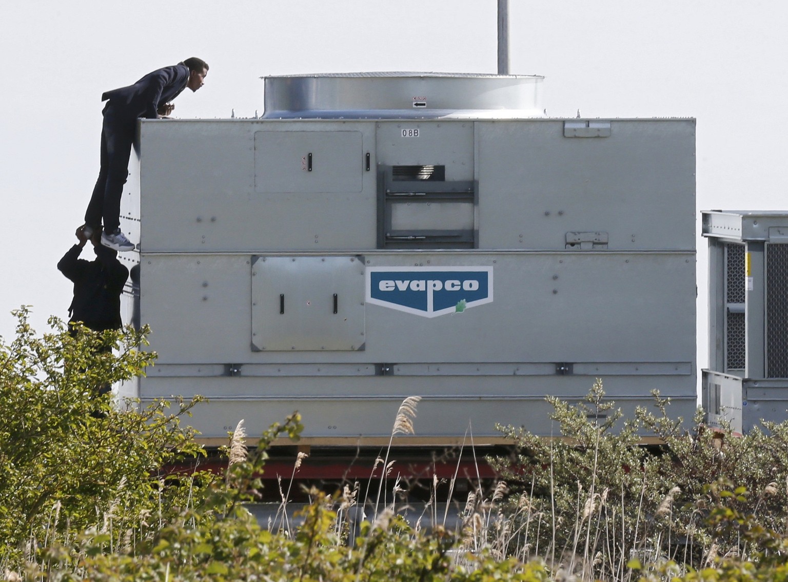 Migranten klettern auf Lastwagen in Calais.