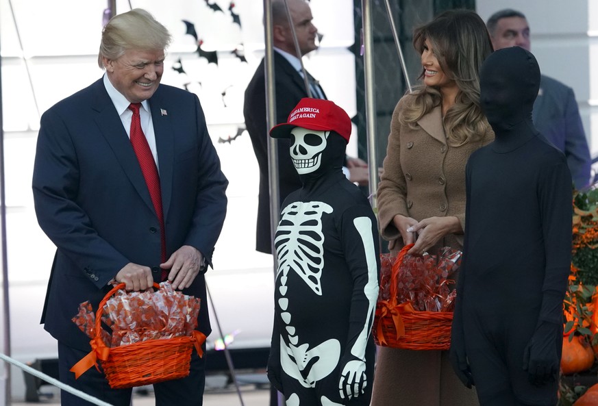 President Donald Trump and first lady Melania Trump hand out treats as they welcome children from the Washington area and children of military families to trick-or-treat celebrating Halloween at the S ...