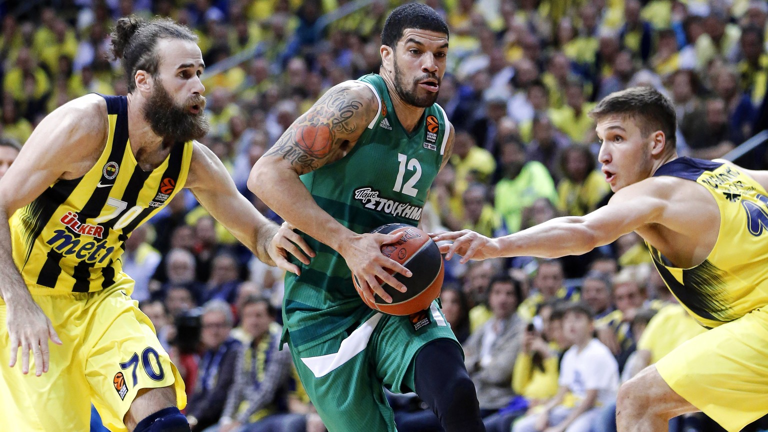 epa05927598 James Feldeine (C) of Panathinaikos in action against Fenerbahce players Luigi Datome (L) and Bogdan Bogdanovic (R) during the Euroleague Playoff round 3 basketball match between Fenerbahc ...