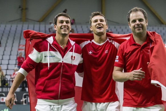 Luca Margaroli, Marco Chiudinelli and Swiss Davis Cup Team captain Severin Luethi, from left, celebrate after the fifth match of the Davis Cup world group playoffs between Switzerland and Belarus, Swi ...