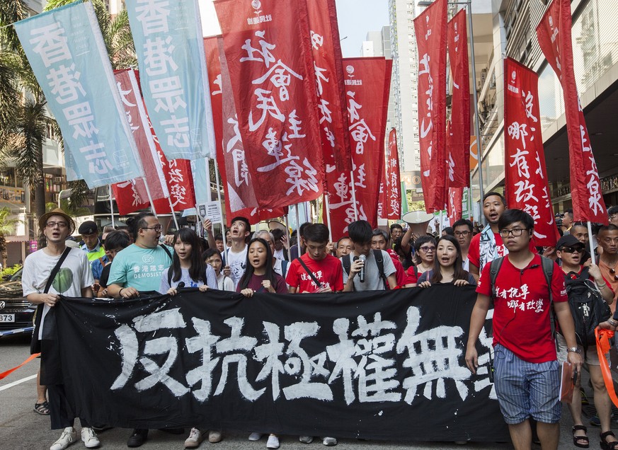 epa06152785 Students lead Hong Kong people with a Chinese banner that reads &#039;Protesting Authoritarianism is not a Crime&#039; as they march through the streets in support of imprisoned student po ...