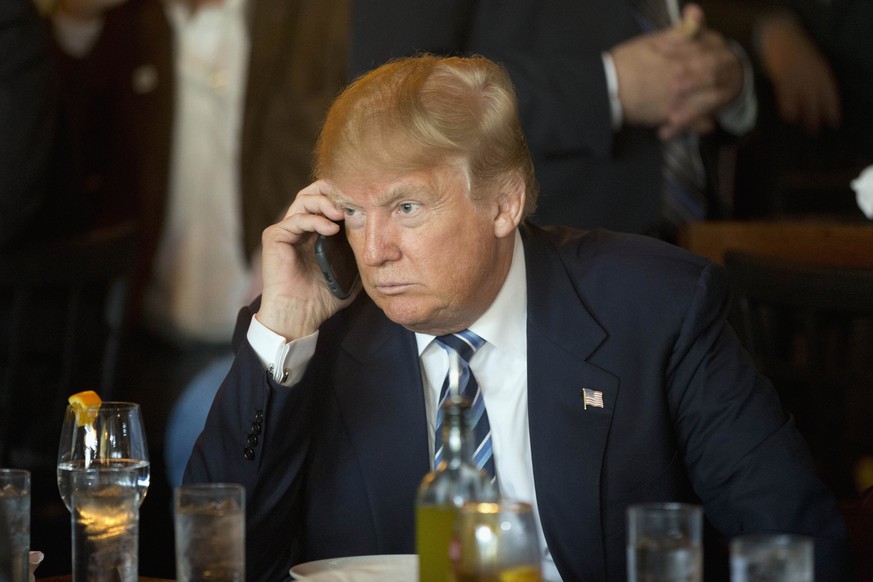 Republican presidential candidate Donald Trump listens to his mobile phone during a lunch stop, Thursday, Feb. 18, 2016, in North Charleston, S.C. (AP Photo/Matt Rourke)