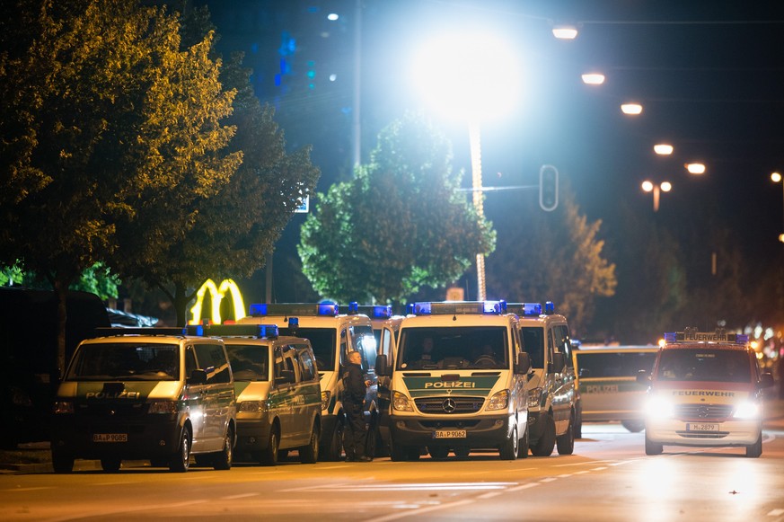 epa05437358 Vehicles of the police are seen near a shopping centre in Munich, Germany, 23 July 2016. According to authorities, at least 10 people died, including the suspect, and 16 were hospitalized  ...