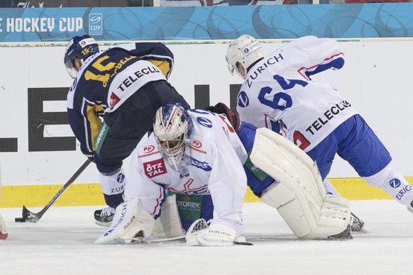 Langenthals Jeff Campbell, links, kaempft um den Puck gegen Klotens Goalie Martin Gerber und Serge Weber, rechts, waehrend dem Swiss Ice Hockey Cup Viertelfinal zwischen dem SC Langenthal und dem EHC  ...