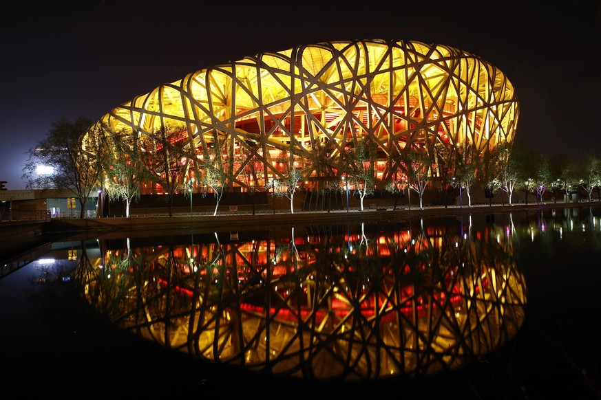 The National Stadium, also known as the &quot;Bird&#039;s Nest&quot;, is seen reflected in a lake before Earth Hour at the Olympic Park in Beijing, March 29, 2014. Lights go off around the world in a  ...