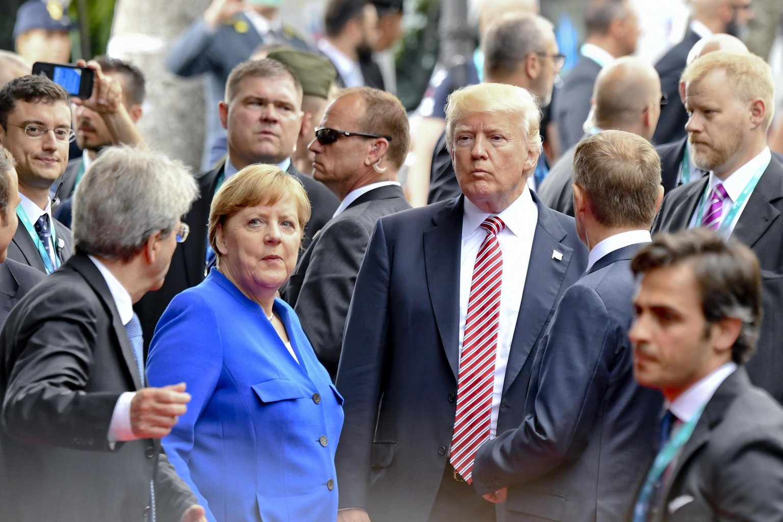 epa05991274 Italian Prime Minister Paolo Gentiloni (R) asks German Chnacellor Angela Merkel (2-L) and US President Donald J. Trump (3-R) to join a walk off after the group photocall at on the first da ...