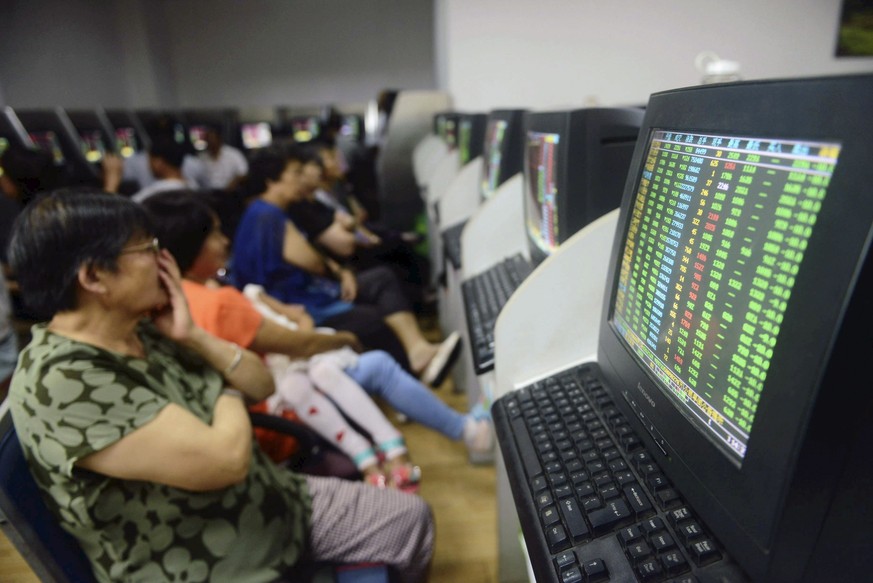 Investoren sitzen vor Computern &nbsp;die die Kursentwicklung zeigen, in der Shandong Provinz in China.