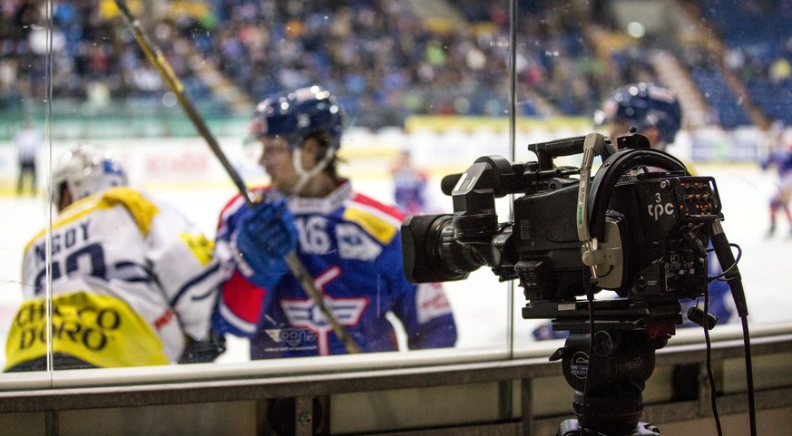 Eine TV Kamera, der Produktionsfirma tpc, steht auf einem Stativ hinter einer Glasscheibe im dritten Eishockey Spiel der Platzierungsrunde der National League A zwischen dem EHC Kloten und dem HC Ambr ...