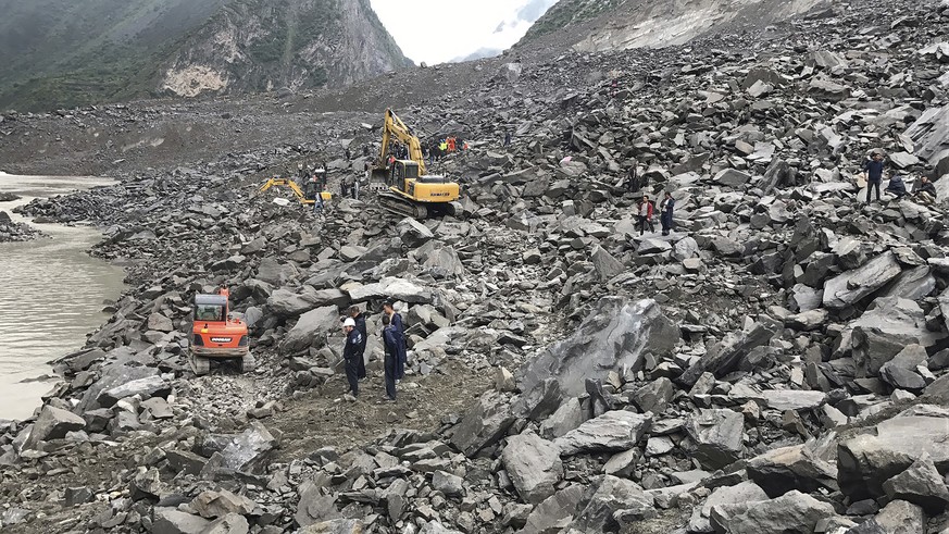 Emergency personnel and earthmoving equipment work at the site of a massive landslide in Xinmo village in Maoxian County in southwestern China&#039;s Sichuan Province, Saturday, June 24, 2017. Dozens  ...