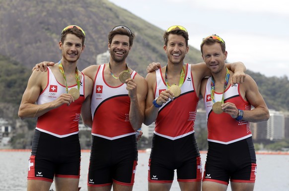 Lucas Tramer, Simon Schuerch, Simon Niepmann, and Mario Gyr, of Switzerland, pose for photographers after winning gold in the men&#039;s rowing lightweight four final during the 2016 Summer Olympics i ...