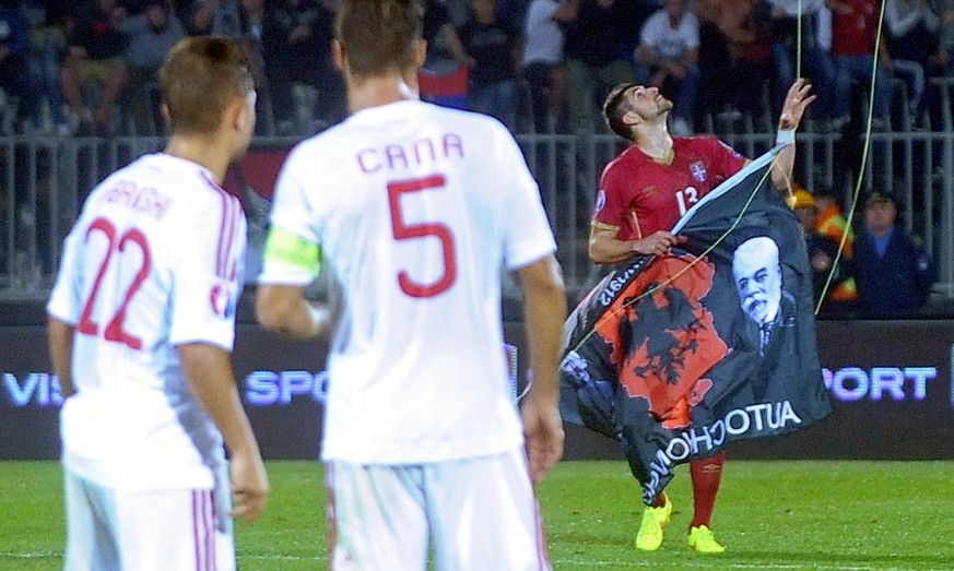 Amir Abrashi schaut mit Captain Lorik Cana zu, wie Stefan Mitrovic sich die gross-albanische Flagge schnappt.