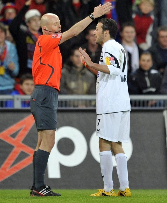 Referee Carlo Bertolini, left, is sending off Neuchatel&#039;s Carlos Varela, right, after showing him the red card during the Super League soccer match between FC Basel and Neuchatel Xamax at the St. ...