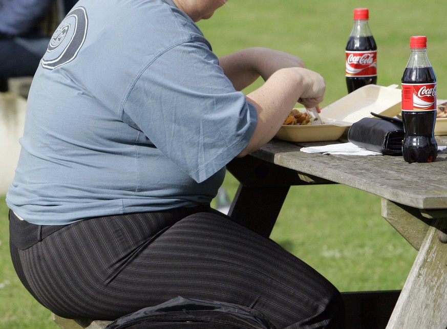 FILE- In this file photo dated Wednesday, Oct. 17, 2007, an overweight person eats in London, Wednesday, Oct. 17, 2007. Almost a third of the world population is now fat, and no country has been able  ...