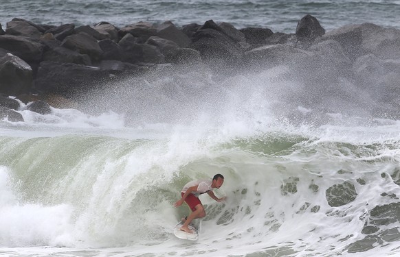 A surfer gets into the tube while surfing the swell from Tropical Storm Hermine at St. Andrews State Park in Panama City Beach, Fla., on Thursday, Sept. 1, 2016. Residents and businesses along Florida ...