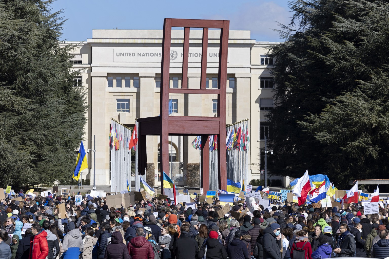 epa09786672 Demonstrators hold placards and flags while protesting Russia&#039;s massive military operation against Ukraine during a rally on the place of the United Nations in Geneva, Switzerland, 26 ...