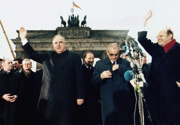 FILE - In this Dec. 22. 1989, file photo, West German chancellor Helmut Kohl, left, waves as he stands together with then East German Prime Minister Hans Modrow, second right, in front of the Brandenb ...