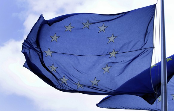 In this Tuesday May 4, 2010 file photo an EU flag blows in the wind outside a meeting of EU transport ministers at the EU Council building in Brussels. The European Union was awarded on Friday Oct. 12 ...