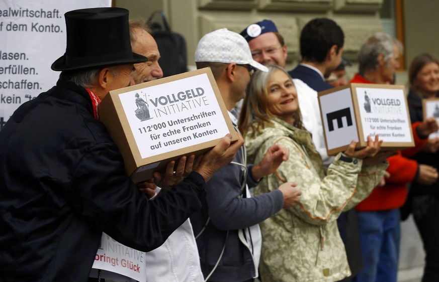 Members of the initiative committee for Monetary Reform (Vollgeld-Initiative) hand over boxes with more than 120.000 signatures at the Federal Chancellery in Bern, Switzerland December 1, 2015. REUTER ...