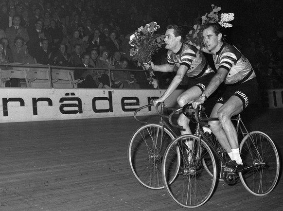 Die Americainesieger Hugo Koblet, rechts, und Armin von Bueren, links, drehen am 1. Januar 1956 bei den Neujahrsrennen im Hallenstadion in Zuerich eine Ehrenrunde. (KEYSTONE/Ilse Guenther)