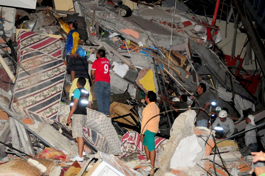 Menschen begutachten ein zerstörtes Gebäude in der&nbsp;ecuadorianischen Hafenstadt Manta.
