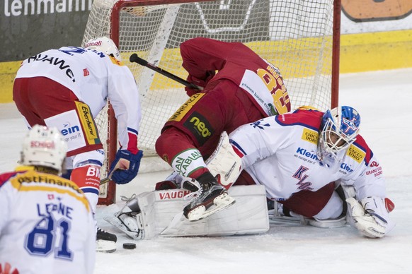 Langanus Thomas Nuessli, Mitte, kaempft um den Puck gegen Klotens Patrick von Gunten, links, und Goalie Luca Boltshauser, rechts, waehrend dem Eishockey-Meisterschaftsspiel der National League A zwisc ...