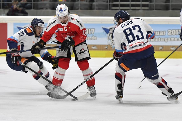 Switzerland’s Anders Ambuehl, center, fights for the puck against Slovakia’s Matej Cesik, right, and Slovakia’s Tomas Matousek during the Ice Hockey Deutschland Cup at the Curt-Frenzel-Eisstadion in A ...