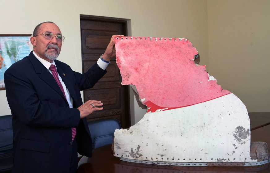 epa05527036 Joao de Abreu, president of Mozambique Civil Aviation Authority, shows one of three pieces of plane debris, possibly belonging to missing flight MH370, during a press conference in Maputo, ...
