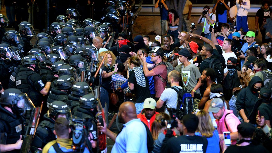 Charlotte-Mecklenburg police officers begin to move protesters down a street in Charlotte, N.C., Wednesday, Sept. 21, 2016. Authorities in Charlotte tried to quell public anger Wednesday after a polic ...