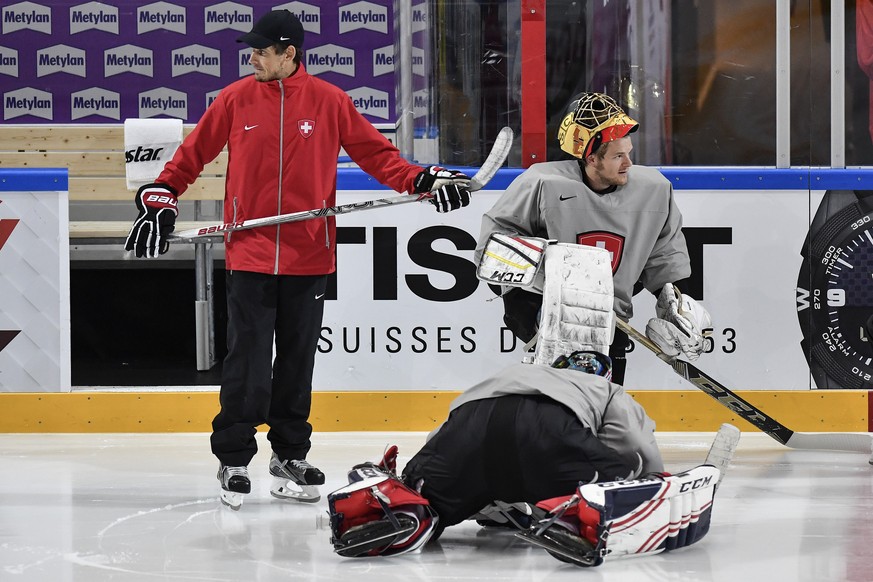 Switzerland’s head coach Patrick Fischer, left, and the goaltender Jonas Hiller, center, and Leonardo Genoni, right, look on during a training session during the Ice Hockey World Championship in Paris ...