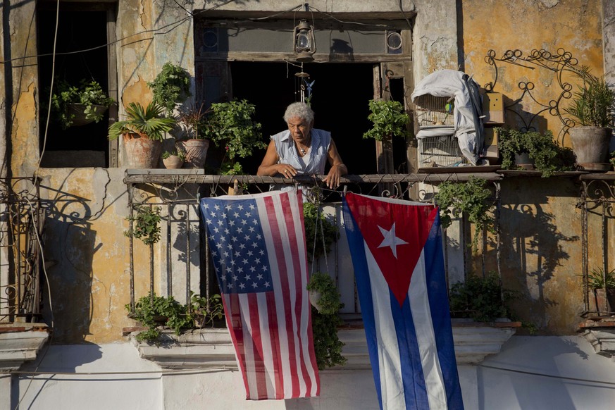 FILE - In this Dec. 19, 2014 file photo, Javier Yanez stands on his balcony decorated with U.S. and Cuban flags in Old Havana, Cuba. On Friday, June 16, 2017, President Donald Trump is expected to tur ...