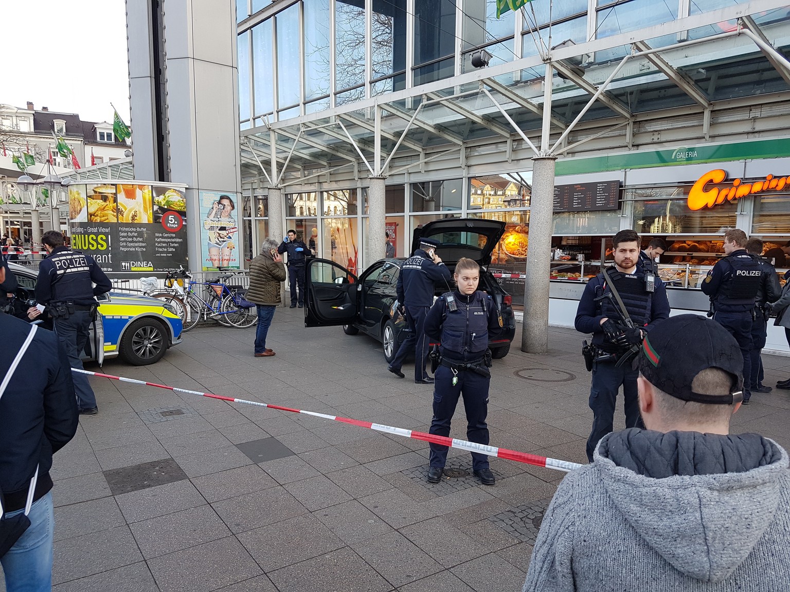 A car stands in front of a store, guarded by police in Heidelberg, Germany, Saturday, Feb. 25, 2017. A man apparently drove a car into pedestrians in a central square in the city of Heidelberg, injuri ...