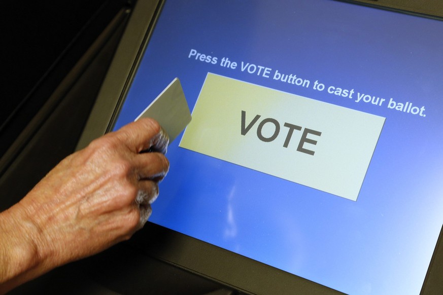 An elections official demonstrates a touch-screen voting machine at the Fairfax County Governmental Center in Fairfax, Virginia, U.S. on October 3, 2012. REUTERS/Jonathan Ernst/File Photo