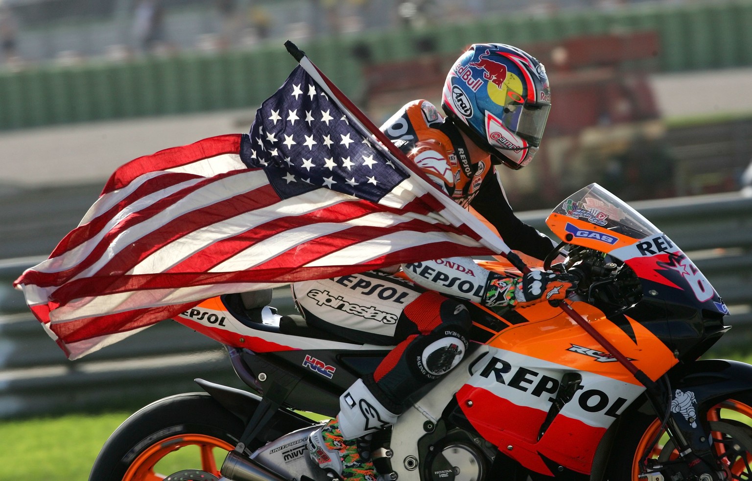 FILE - In this Oct. 29, 2006, file photo, United States Honda rider Nicky Hayden holds a U.S. flag after winning the world championship GP at the Cheste racetrack near Valencia, Spain. The Maurizio Bu ...