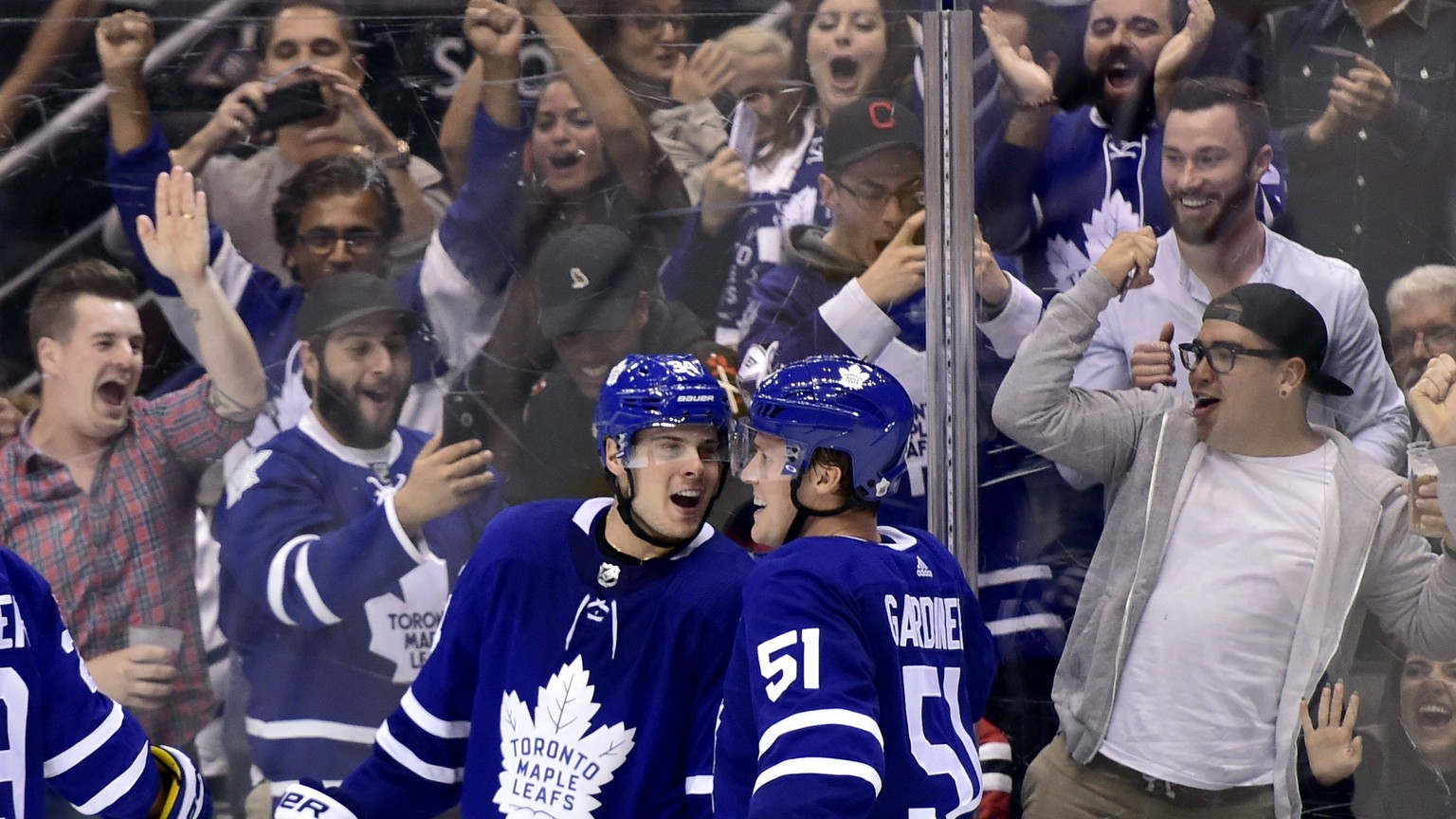 Toronto Maple Leafs centre Auston Matthews (34) celebrates his game-winning goal with teammate Jake Gardiner (51) during overtime of an NHL hockey game against the Chicago Blackhawks in Toronto on Mon ...