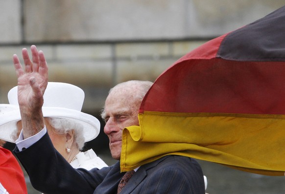 A German flag flutters onto the head of Prince Philip, the Duke of Edingburgh, during a boat tour on the river Spree near the Reichstag building in Germany's capital Berlin, Wednesday, June 24, 2 ...