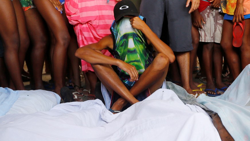 ATTENTION EDITORS - VISUAL COVERAGE OF SCENES OF DEATH AND INJURYA youth covers his face near bodies of whom police say are drug traffickers, during a police operation in the Cidade de Deus favela, Ri ...