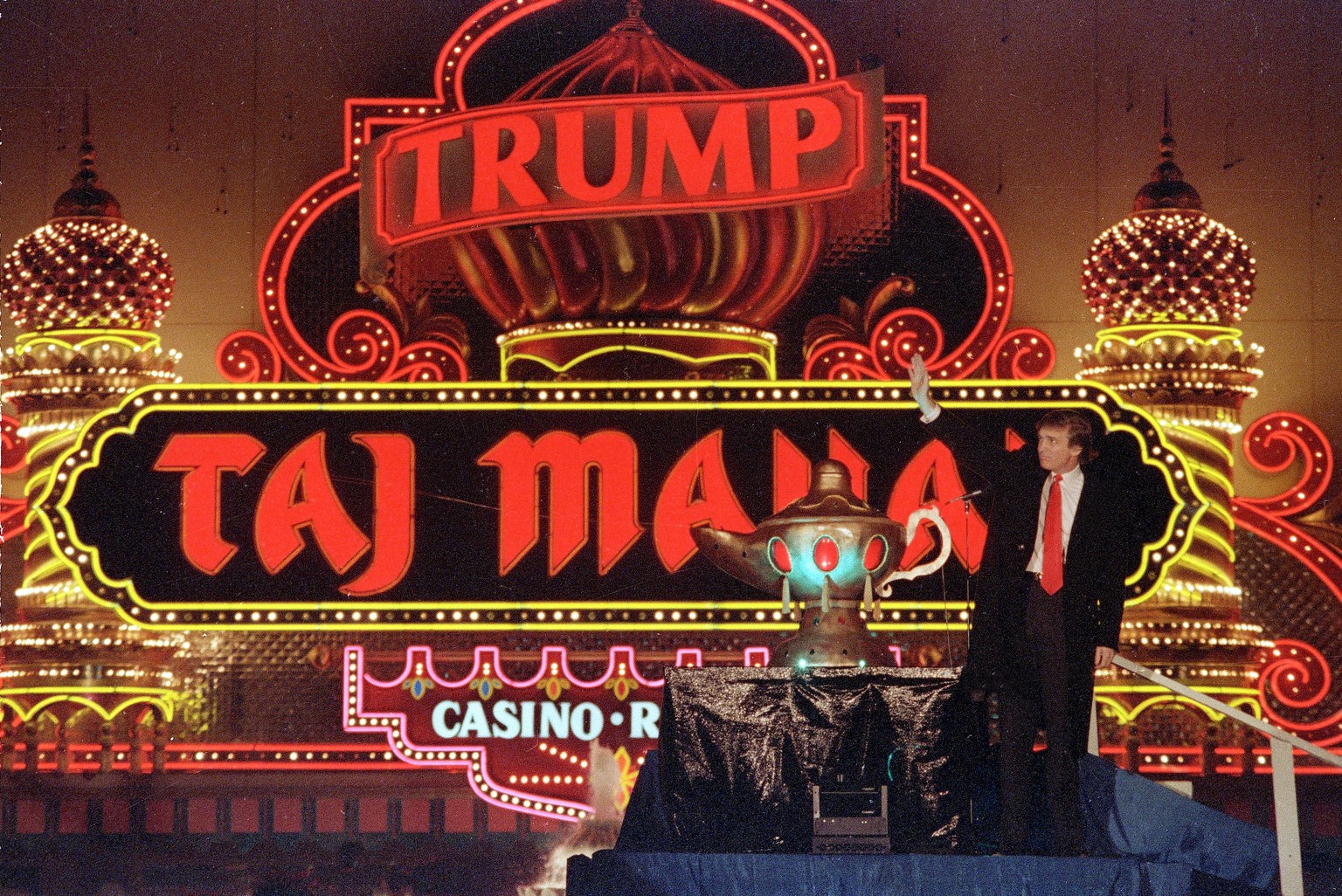 FILE - In this April 5, 1990 file photo, Donald Trump stands next to a genie lamp as the lights of his Trump Taj Mahal Casino Resort light up the evening sky marking the grand opening of the venture i ...