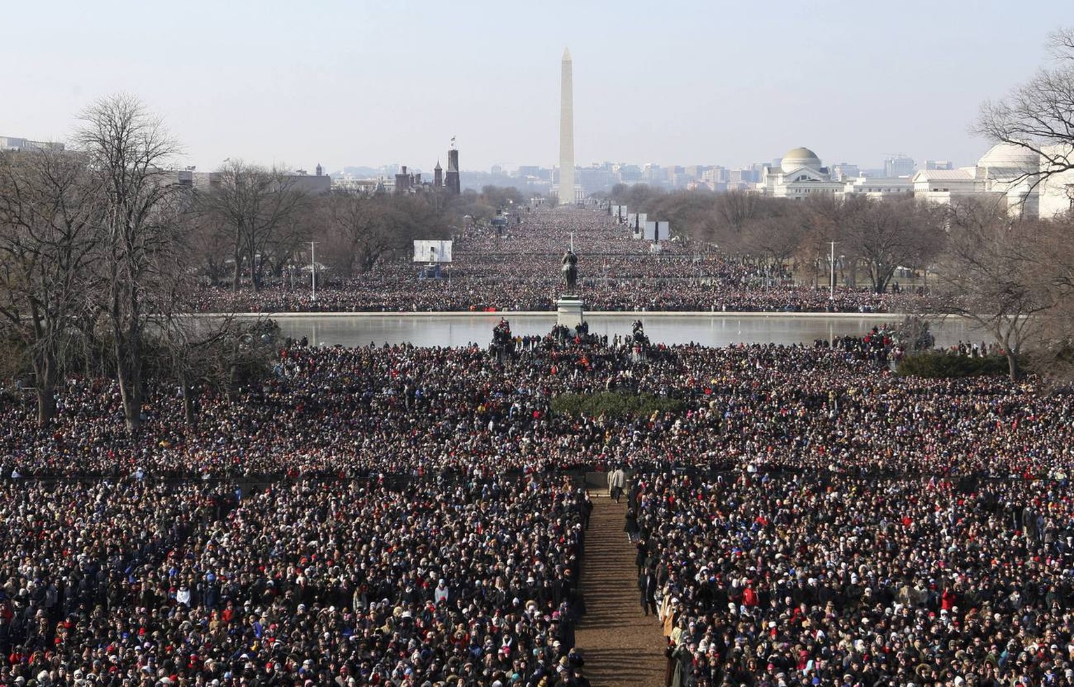 Crowds gather to watch the inauguration of President Barack Obama Tuesday, Jan. 20, 2009, on the west side of the Capitol in Washington. The Washington Monument can be seen in the background. (AP Phot ...