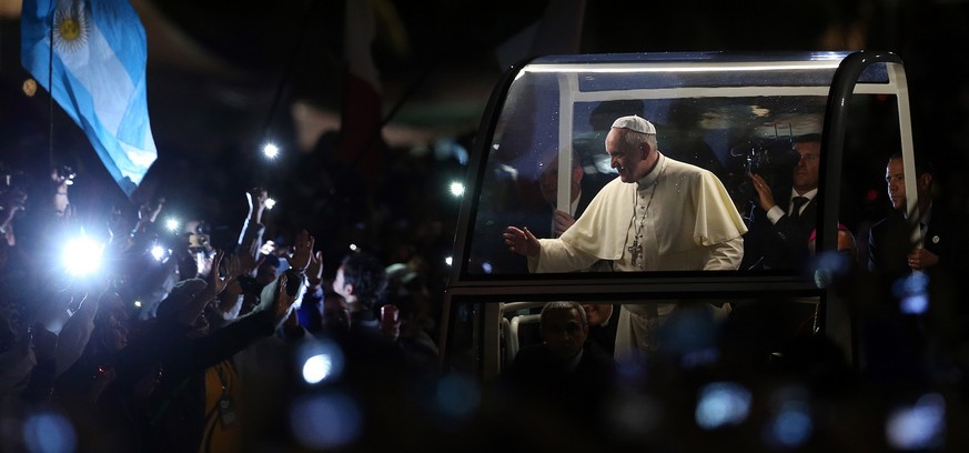 Pope Francis waves as arrives for a World Youth Day celebration on the Copacabana beachfront in Rio de Janeiro, Brazil, Thursday, July 25, 2013. Francis traveled in his open-sided car through a huge c ...